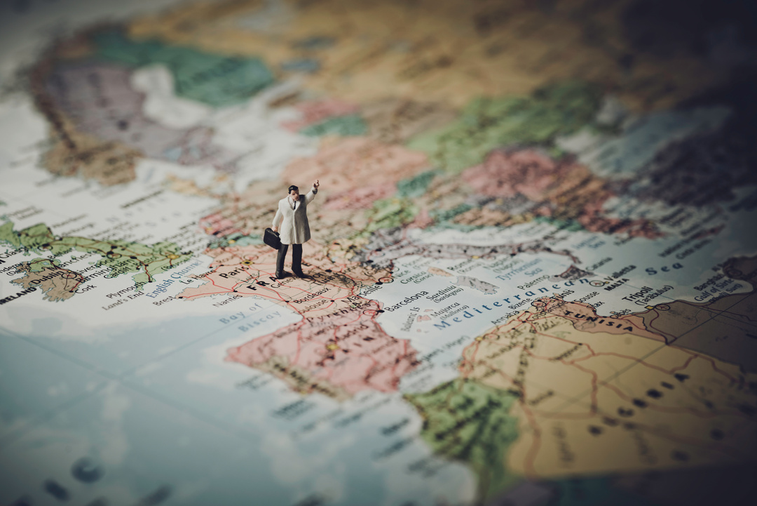 Miniature Businessman on Map of Europe